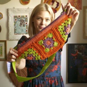 Nerka szydełkowana kwiat fioletowy na pomarańczowym